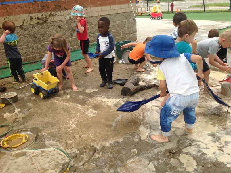 children plyaing in mud with toys
